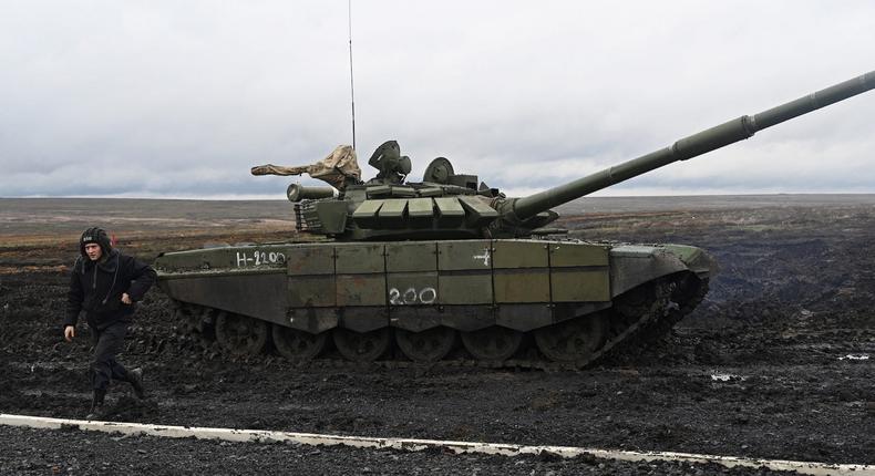 A Russian service member walks near a T-72B3 main battle tank during military drills at the Kadamovsky range in the Rostov region of Russia on December 20, 2021.