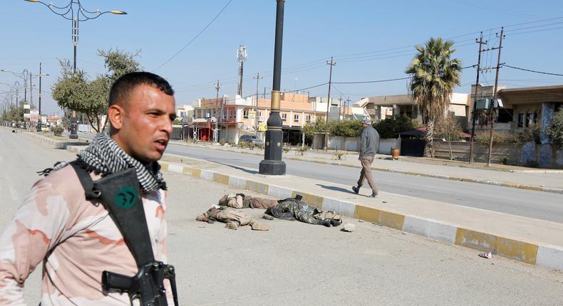 An Iraqi soldier with his weapon near corpses of ISIS militants killed in clashes in Mosul, February 6, 2017.