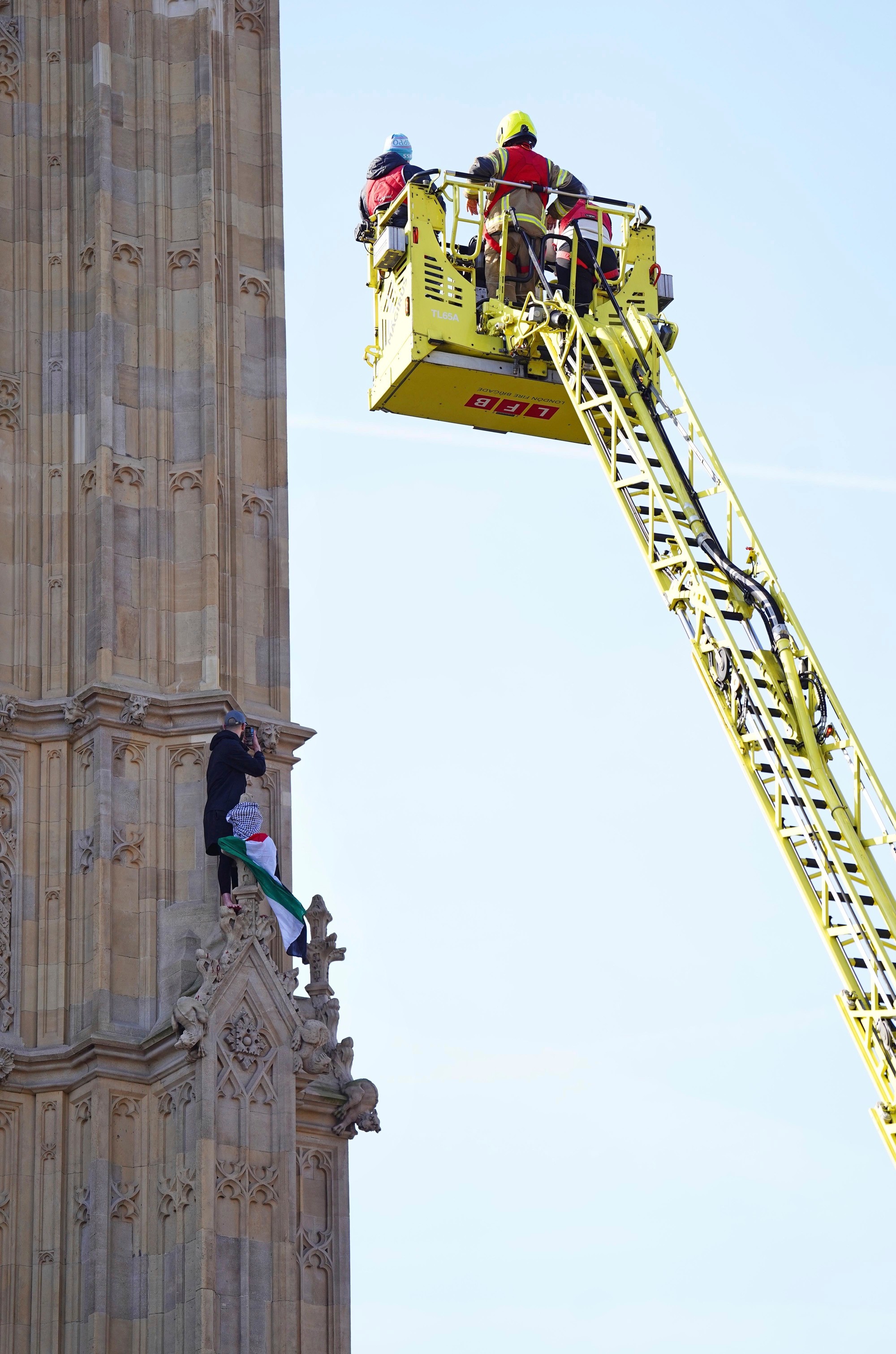 Na snímke príslušníci záchranných zložiek zasahujú po tom, čo sa muž s palestínskou vlakou vyšplhal na Big Ben (oficiálne Alžbetina veža) Westminsterského paláca v Londýne v sobotu 8. marca 2025.