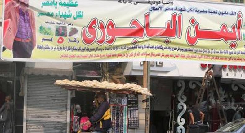 A street vendor rides a bicycle under election campaign banners in downtown Cairo, ahead of the second round of parliamentary election, November 19, 2015.