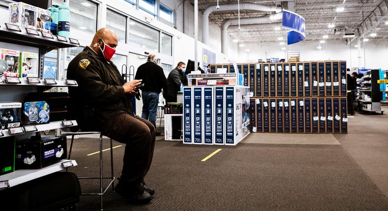 A police officer wears a mask while sitting on guard at a Best Buy in Kentucky.