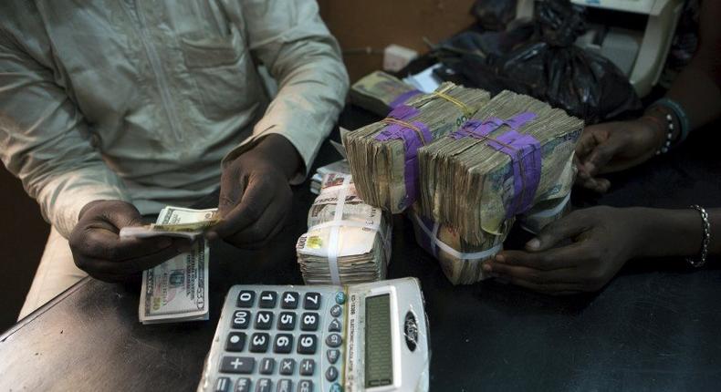 A trader changes dollars with naira at a currency exchange store in Lagos, Nigeria in this February 12, 2015 file photo. NigeriaÃ¢â‚¬â„¢s central bank is expected to make an interest rate decision this week.  REUTERS/Joe Penney/File