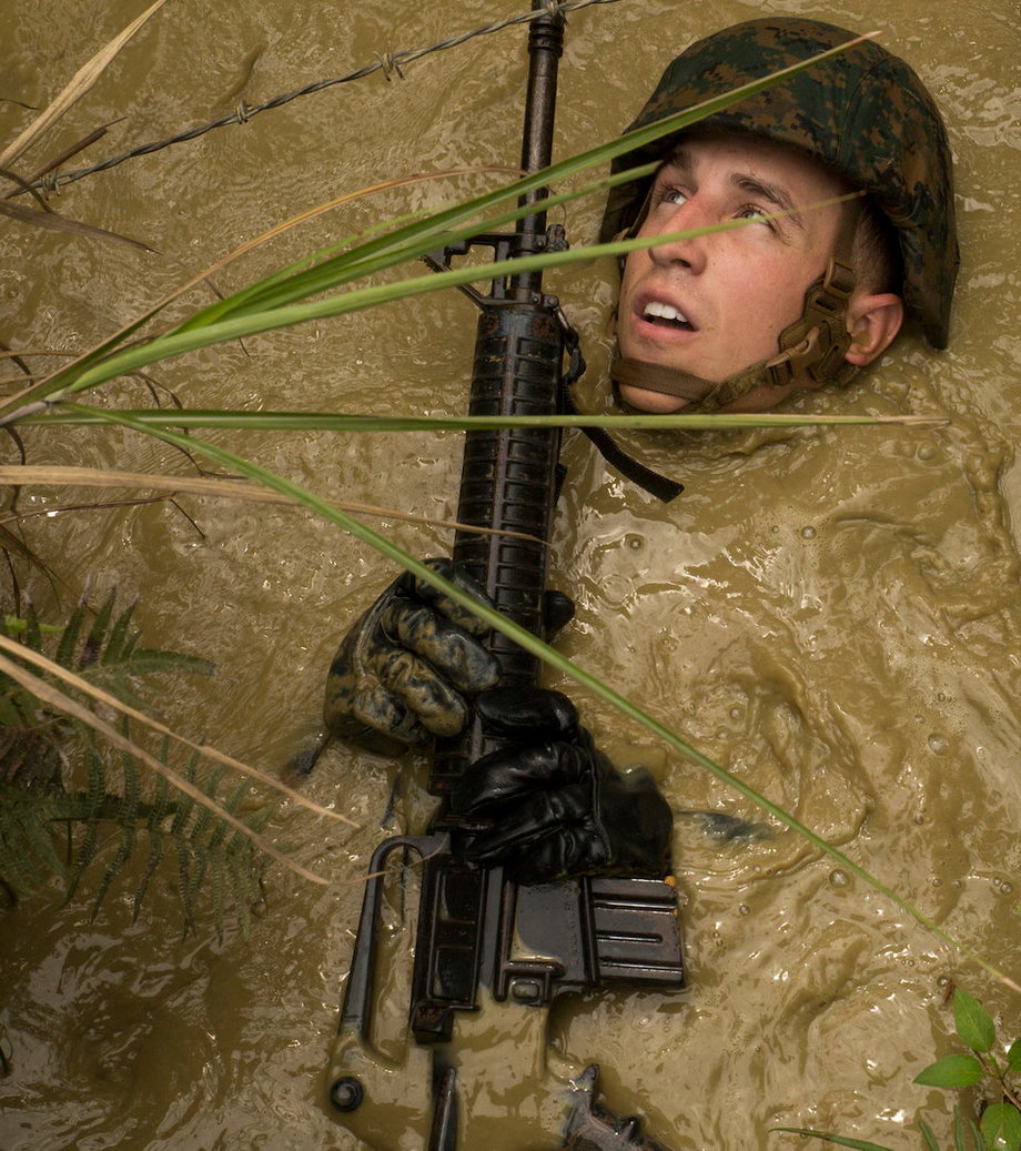 Na zdjęciu żołnierz Kevin E. Kusler, który pływa w błocie podczas kursu wytrzymałościowego w dżungli.