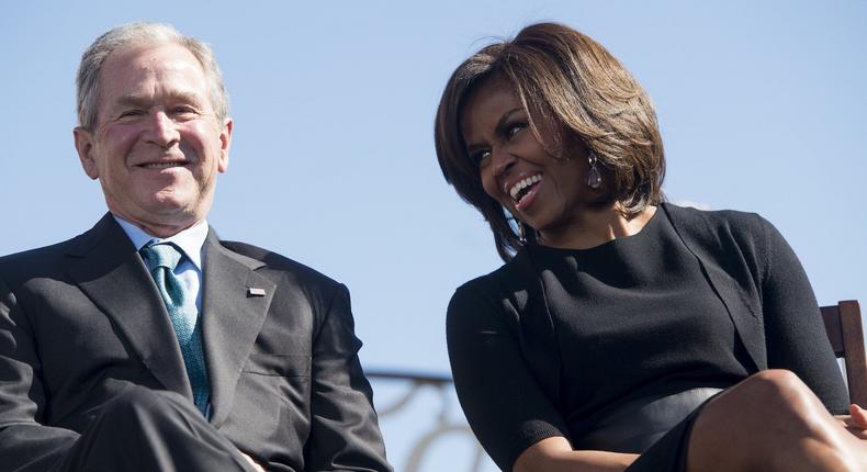 Former US President George W. Bush smiles as he speaks with First Lady Michelle Obama during an event marking the 50th Anniversary of the Selma to Montgomery civil rights marches at the Edmund Pettus Bridge in Selma, Alabama, March 7, 2015.