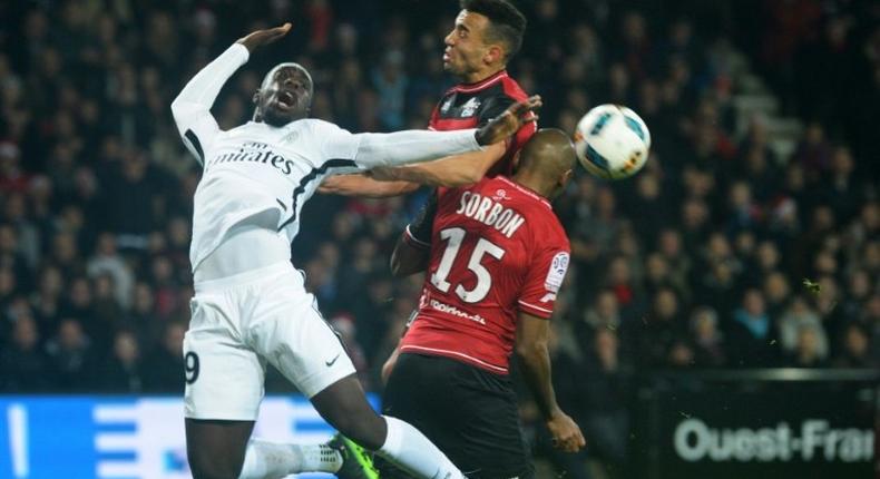 Paris Saint-Germain's Jean-Kevin Augustin (L) vies with Guingamp's Jeremy Sorbon (R) on December 17, 2016 at the Roudourou stadium in Guingamp, western of France