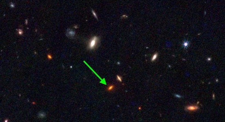 An arrow points to JWST-7329, a rare massive galaxy that is thought to be 13 billion years old.JWST NIRCAM