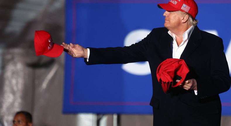 Former President Donald Trump tosses a MAGA hat to the crowd before speaking at a rally at the Canyon Moon Ranch festival grounds on January 15, 2022 in Florence, Arizona.