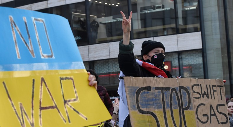 Demonstrators in Duesseldorf, Germany hold signs reading No War and Stop Swift, Gas, Putin.