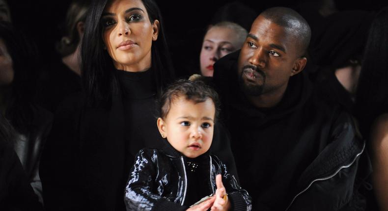 The way you view status and likability gets passed on to your kids. Kim Kardashian West, Kanye West, and their daughter North are pictured.