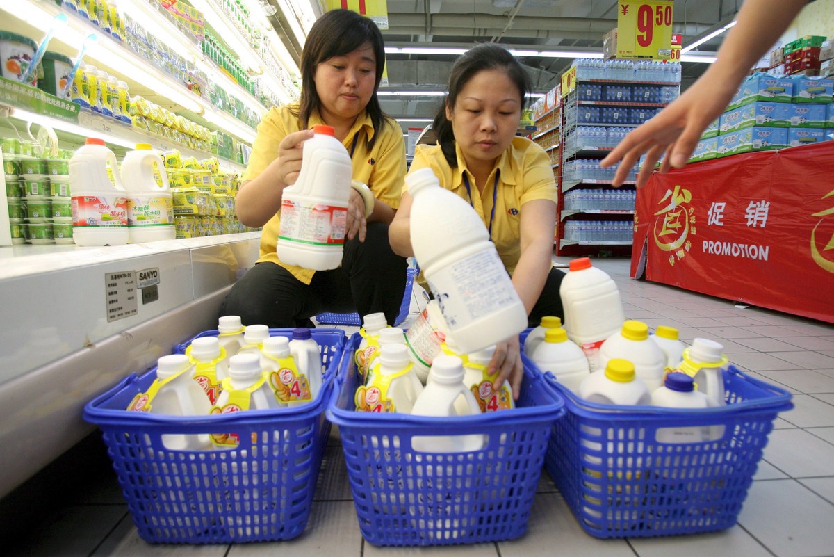 Pracownice zabierają mleko z półek supermarketu w Wuhan