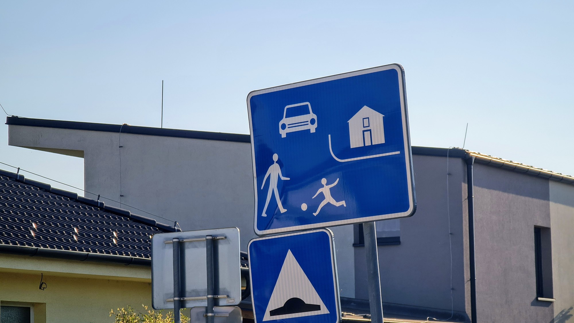 Dopravné značky označujúce začiatok obytnej zóny a spomaľovací prah
