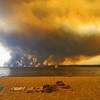 Posetioci plaže odmaraju se na plaži Mučik na obali jezera Lakano u Lakanou, na jugozapadu Francuske, dok požar besni u Žirondi, 24. jul 2026.
