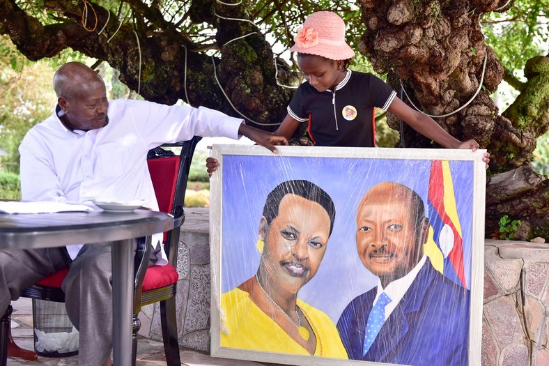 9-year-old Sheila Sheldon Charles presents President Yoweri museveni with another portrait during her visit to Uganda (Twitter) 