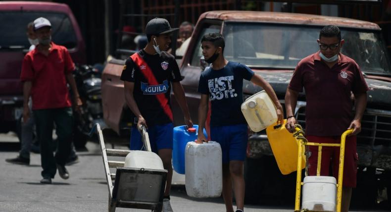 A man carries water in Caracas May 19, 2020 amid the coronavirus pandemic