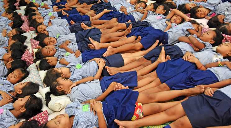 Általános iskolások erőforrásokat tankolnak Kambodzsában. Erőszünetnek (powernapping) nevezik ezt a rövid, és nem túl mély alvási szünetet / Fotó: Getty Images