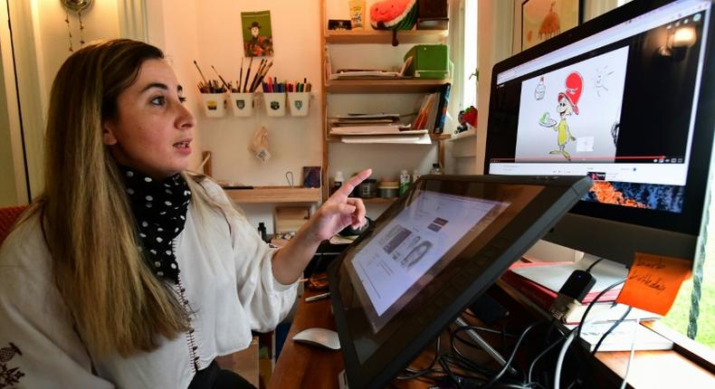 Artist Reem Ali Adeeb gestures while pointing out the Netflix production of Green Eggs and Ham on which she worked, in her studio apartment in Los Angeles, California on April 29, 2020