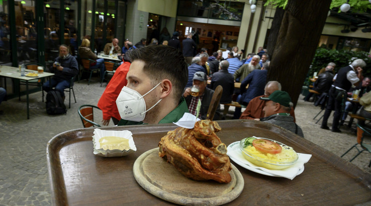 Ételt visz ki az asztalokhoz egy pincér a Schweizerhaus sörkertben a bécsi Práterben / Fotó: MTI/EPA/Christian Bruna