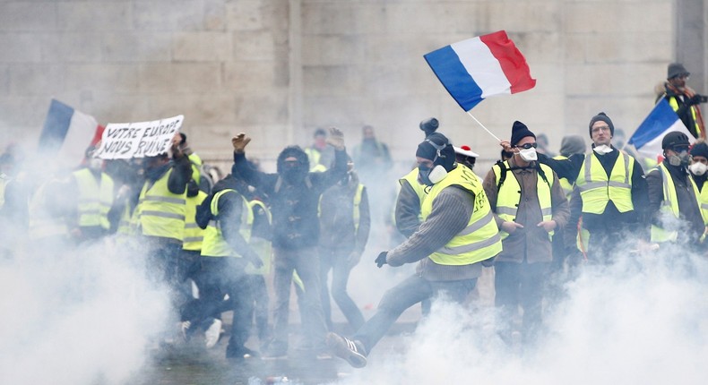 Protesters wearing yellow vests, a symbol of a French drivers' protest against higher diesel taxes, face off with French riot police during clashes at the Place de l'Etoile near the Arc de Triomphe in Paris, France, December 1, 2018.