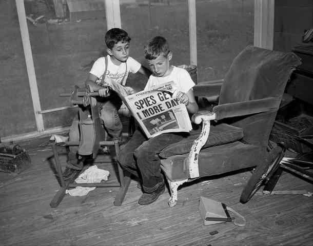 Synowie Rosenbergów, 10-letni Michael i 6-letni Robert, czytają artykuł o swoich rodzicach w domu przyjaciół w Toms River w stanie New Jersey, 1953 r.