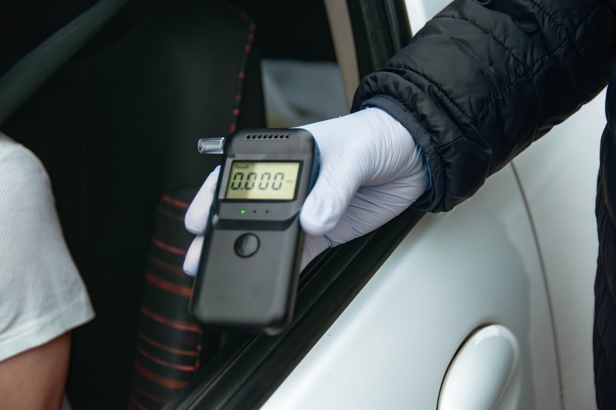 Officer,Wearing,Glove,Administering,Breathalyzer,To,Driver,At,Roadside,Stop,