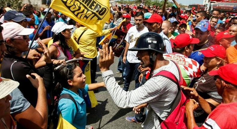 Venezuelan Government' supporters (R) clash against President Maduro opponents during a demonstration to demand a recall referendum against Maduro