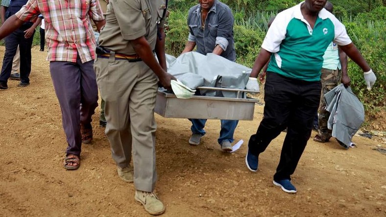 Policemen carry the dead bodies