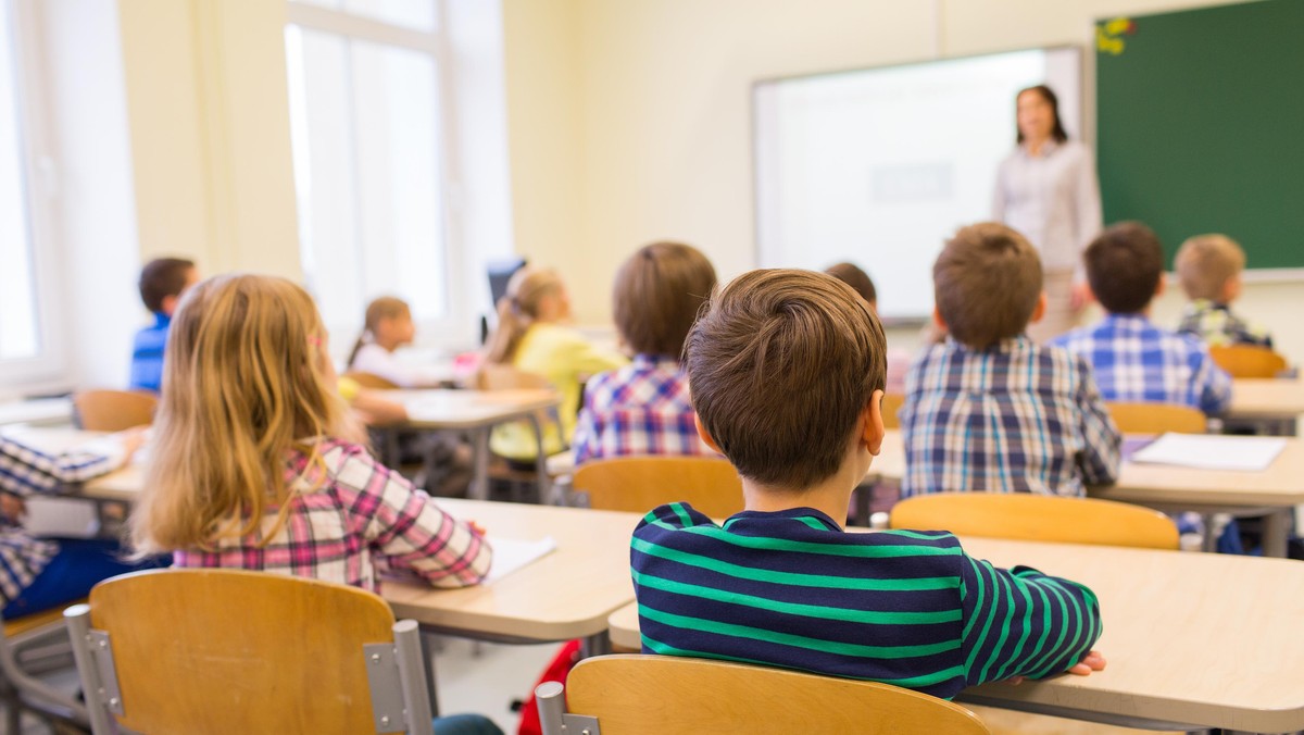 group of school kids and teacher in classroom