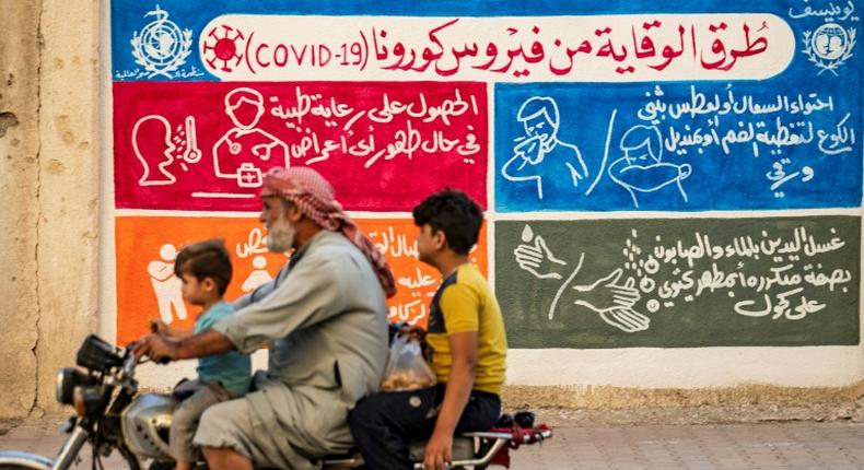 A mural in the Kurdish-majority city of Qamishli in northeastern Syria urges people to protect themselves from the virus as part of a campaign by the UN childre's fund UNICEF and the World Health Organization