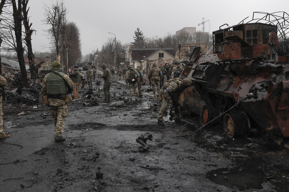 Ukraińscy żołnierze sprawdzają zniszczone rosyjskie maszyny wojskowe w Buczy