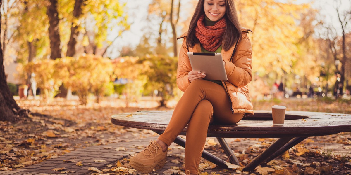 Photo of pretty lovely lady smiling sit bench hold tablet drink coffee remotely contacting professor