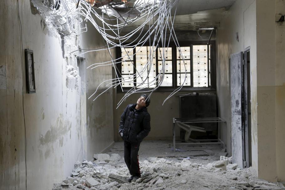 A boy inspects damage inside his school, due to what activists said was an air strike carried out ye