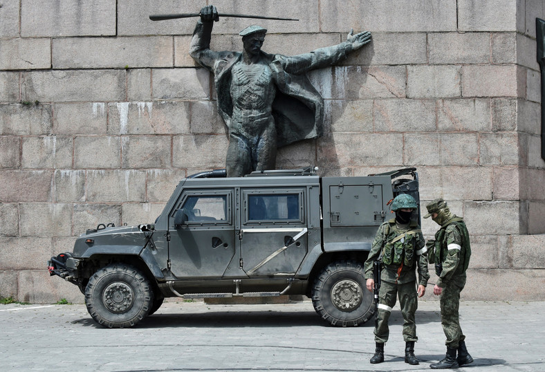 Rosyjscy żołnierze obok pojazdu z literą Z, który jest symbolem jednostek armii Rosji w Ukrainie