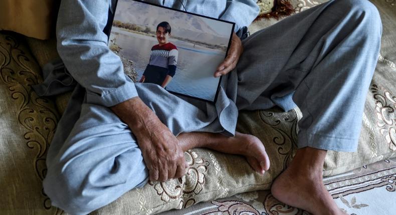 Juma Khan, 77, holds a picture of his son Aziz Ahmad Naween, who was killed in a massive truck bombing near the German embassy in Kabul in 2017