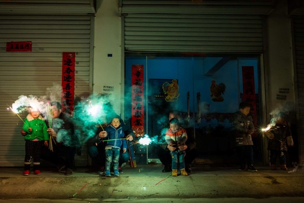 Children play with fire crackers on the eve of the Chinese Lunar New Year, or the Spring Festival, i