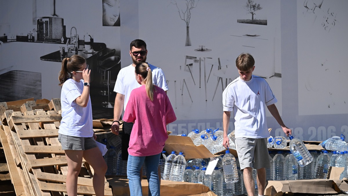 Lokalni stanovnik nosi flaše sa vodom za piće iz humanitarne pomoći koju su dopremili volonteri u Džankoju na Krimu