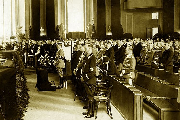 Adolf Hitler stoi obok symbolicznej trumny Józefa Piłsudskiego podczas uroczystości w katedrze św. Jadwigi.