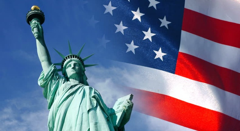 Statue of Liberty and United States flag waving in wind