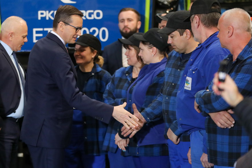 18 maja 2023 r., premier Mateusz Morawiecki wita się z załogą Newagu w Nowym Sączu. Towarzyszy mu prezes firmy Zbigniew Konieczek (z lewej)