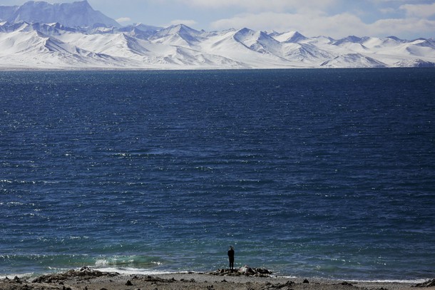 A Tibetan man stands at shores of Namtso lake in the Tibet Autonomous Region