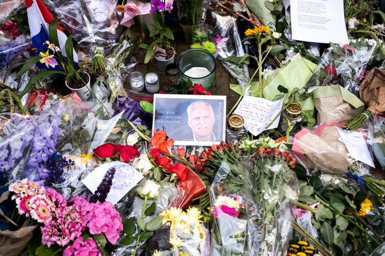 Ludzie składają kwiaty i zdjęcia na ulicy Lange Leidsedwarsstraat w Amsterdamie, gdzie zastrzelono reportera kryminalnego zajmującego się działalnością karteli narkotykowych — Petera R. de Vriesa, 2021 r.