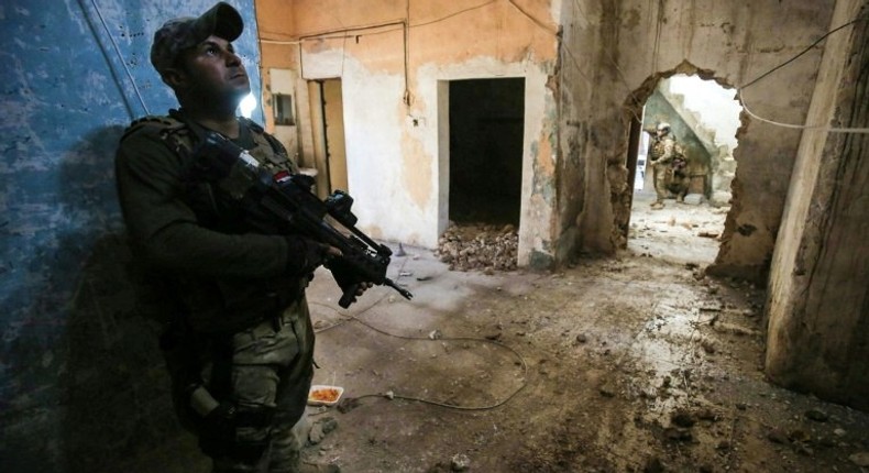 Iraqi forces advance in a house in the Old City in west Mosul on March 17, 2017