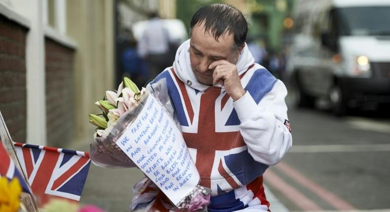 A man lays flowers at a makeshift memorial near Borough Market in London