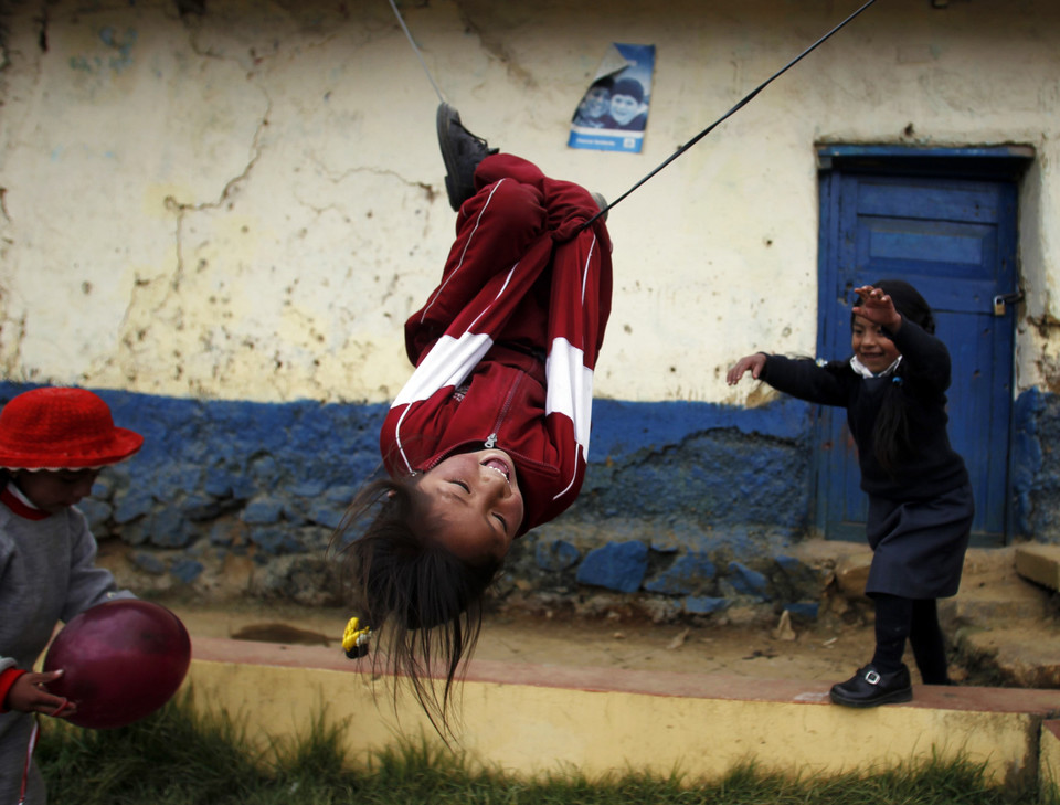 Girls play with a swing at the Andean town of Morococha May 13, 2010.