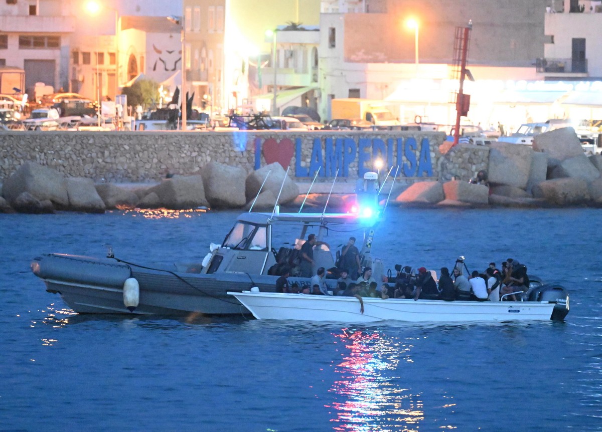 Mała łódka z migrantami eskortowana przez włoską łódź patrolową w porcie Lampedusa we Włoszech, 19 września 2023 r.