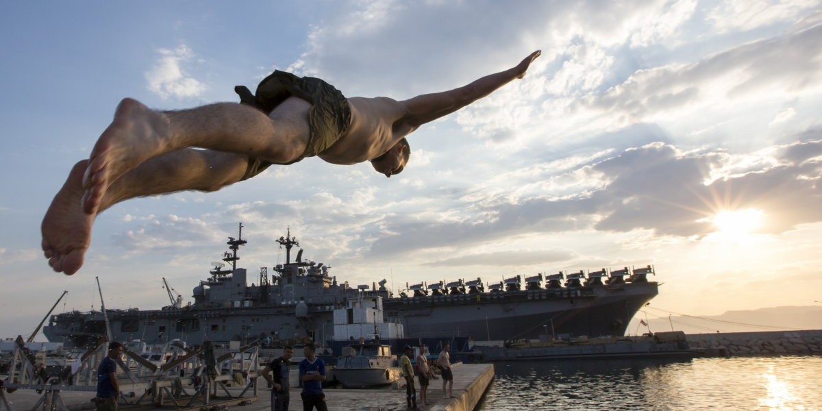 Żołnierz piechoty morskiej skacze do wody z USS Kearsarge w Akabie w Jordanii