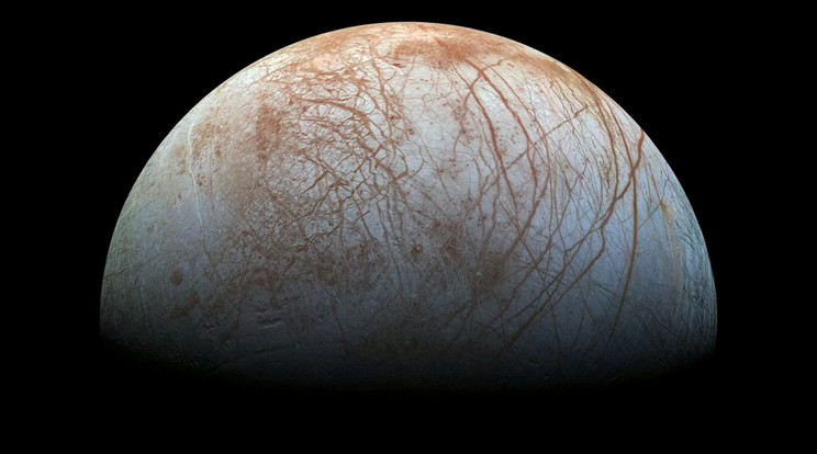 A Jupiter egyik jeges holdja, az Europa, a felszínén látványos mintázatot alkotó repedésekkel. A jeges felszín alatt egy óceán húzódik, amelyből vízgőzcsóvák törnek ki az űrbe. Elég nagy esély van rá, hogy ezen az égitesten megtalálható az élet valamilyen formája. / Fotó: NASA/JPL-Caltech