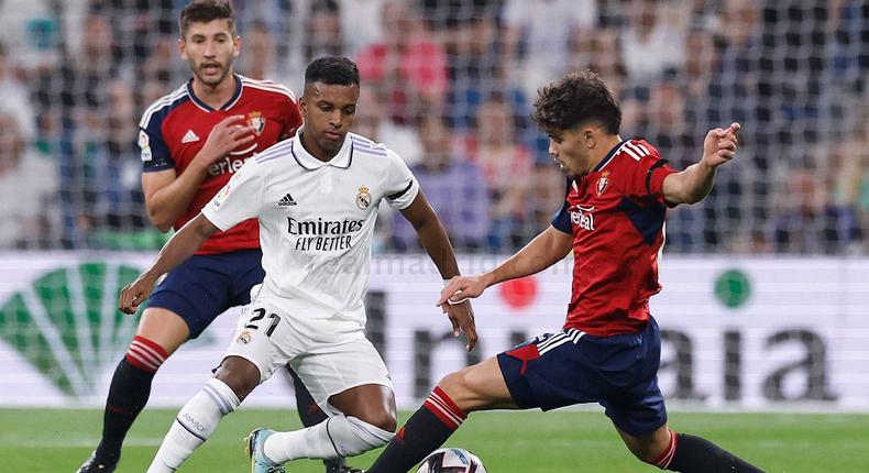 Osasuna players tackling Real Madrid forward Rodrygo Goes