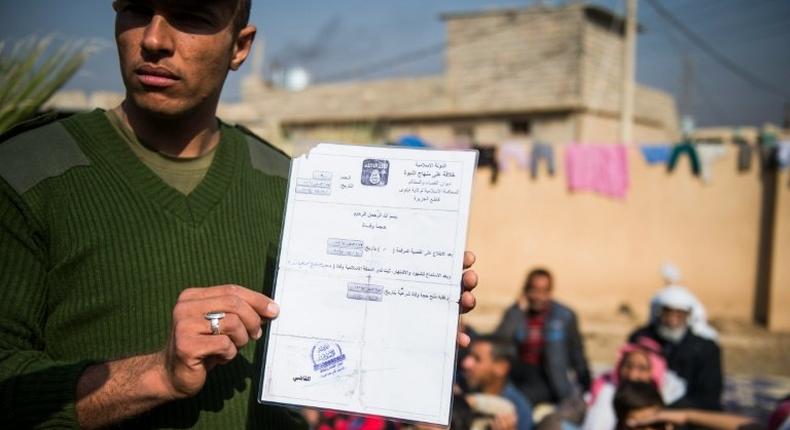 An Iraqi soldier from the Iraqi army 9th armoured division holds a death certificate issued by the Islamic State next to a base adjacent to the Al-Intissar neighbourhood of Mosul, on November 7, 2016