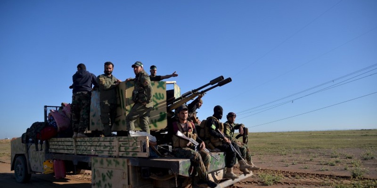 Members of the Hashid Shaabi Shi'ite militia gather in the west of Samarra, in the desert of Anbar, as they prepare to depart for Mosul to fight against Islamic State.