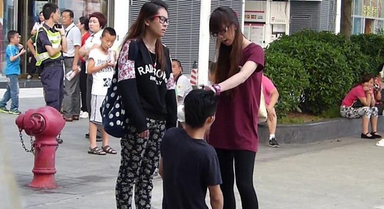 A Chinese woman has been arrested after forcing her boyfriend to kneel in the street and repeatedly slapping him around the face.